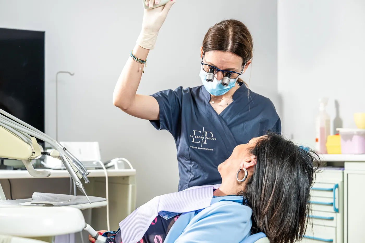 Seduta di igiene professionale con occhialini ingrandenti nello studio dentistico di Bra